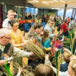 Grupa ludzi robiących palmy wielkanocne