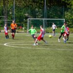 Młodzi piłkarze na boisku w trakcie meczu