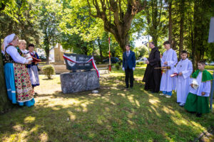 Osoby zgromadzone przy tablicy pamiątkowej