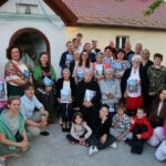 Grupa modlących się przy kapliczce osób