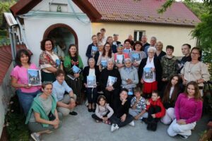 Grupa modlących się przy kapliczce osób