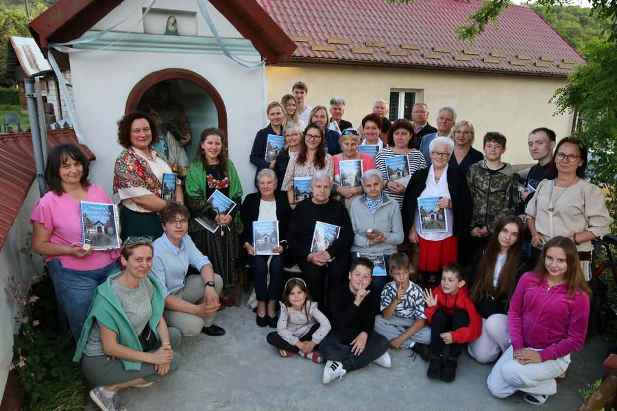 Grupa modlących się przy kapliczce osób